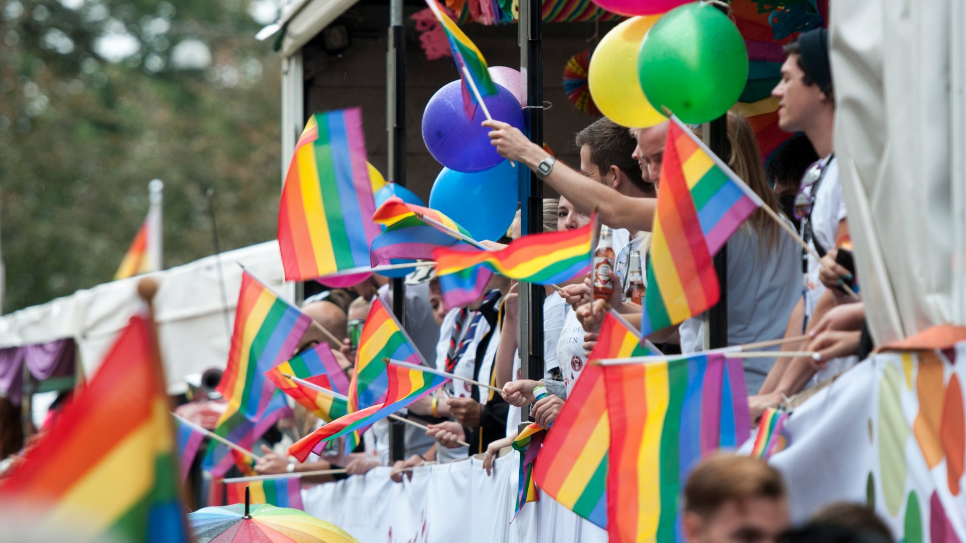 Pessoas com a Pride Flag durante a Parada Gay