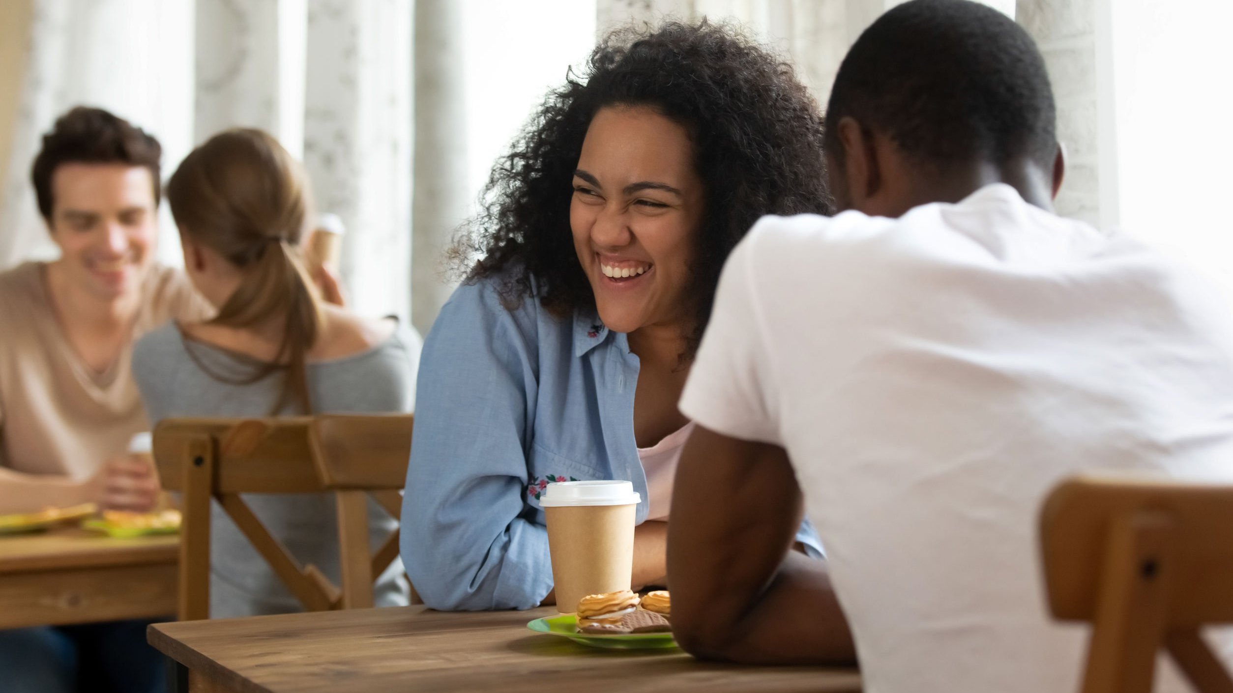 Homem e mulher rindo sentados em um restaurante