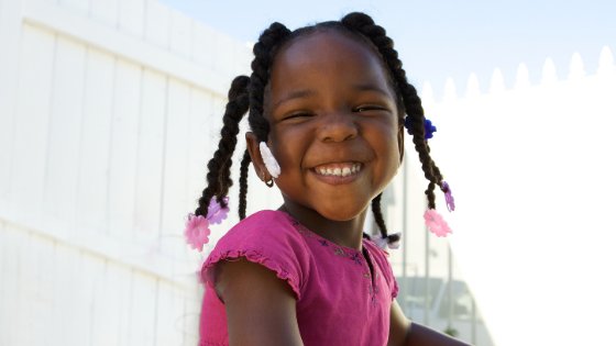 Criança sorrindo e olhando para frente