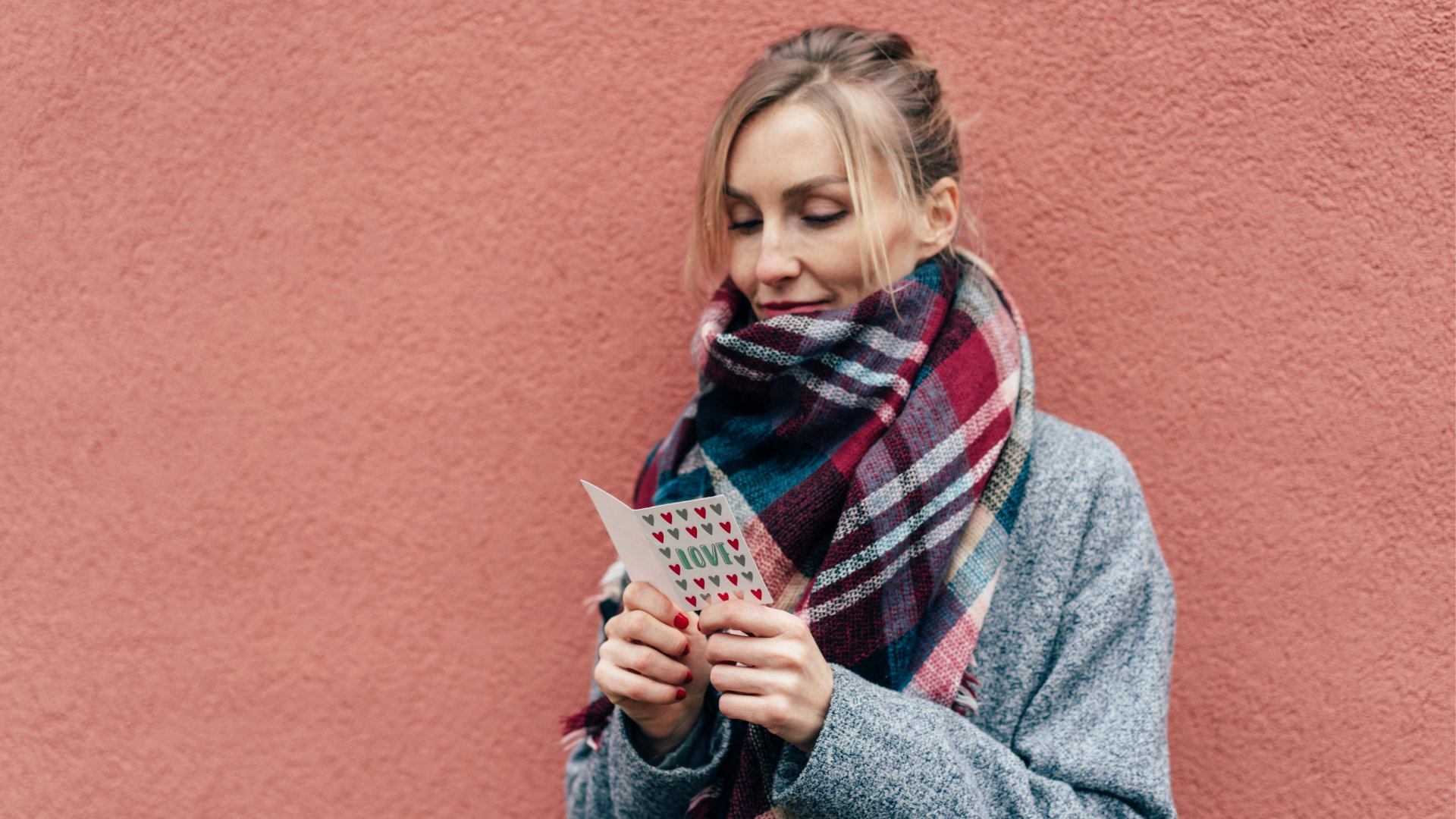 Mulher sorrindo enquanto lê uma carta romântica