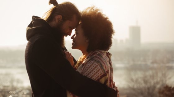 Guruxoox/Canva Casal um de frente para o outro sorrindo