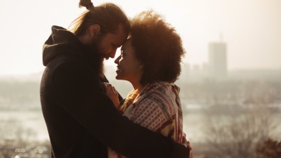 Casal um de frente para o outro sorrindo