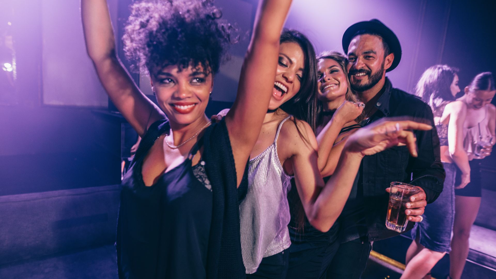 Mensagens Com Amor / Canva / Jacob Lund Imagem de quatro pessoas dançando na balada, três mulheres e um homem