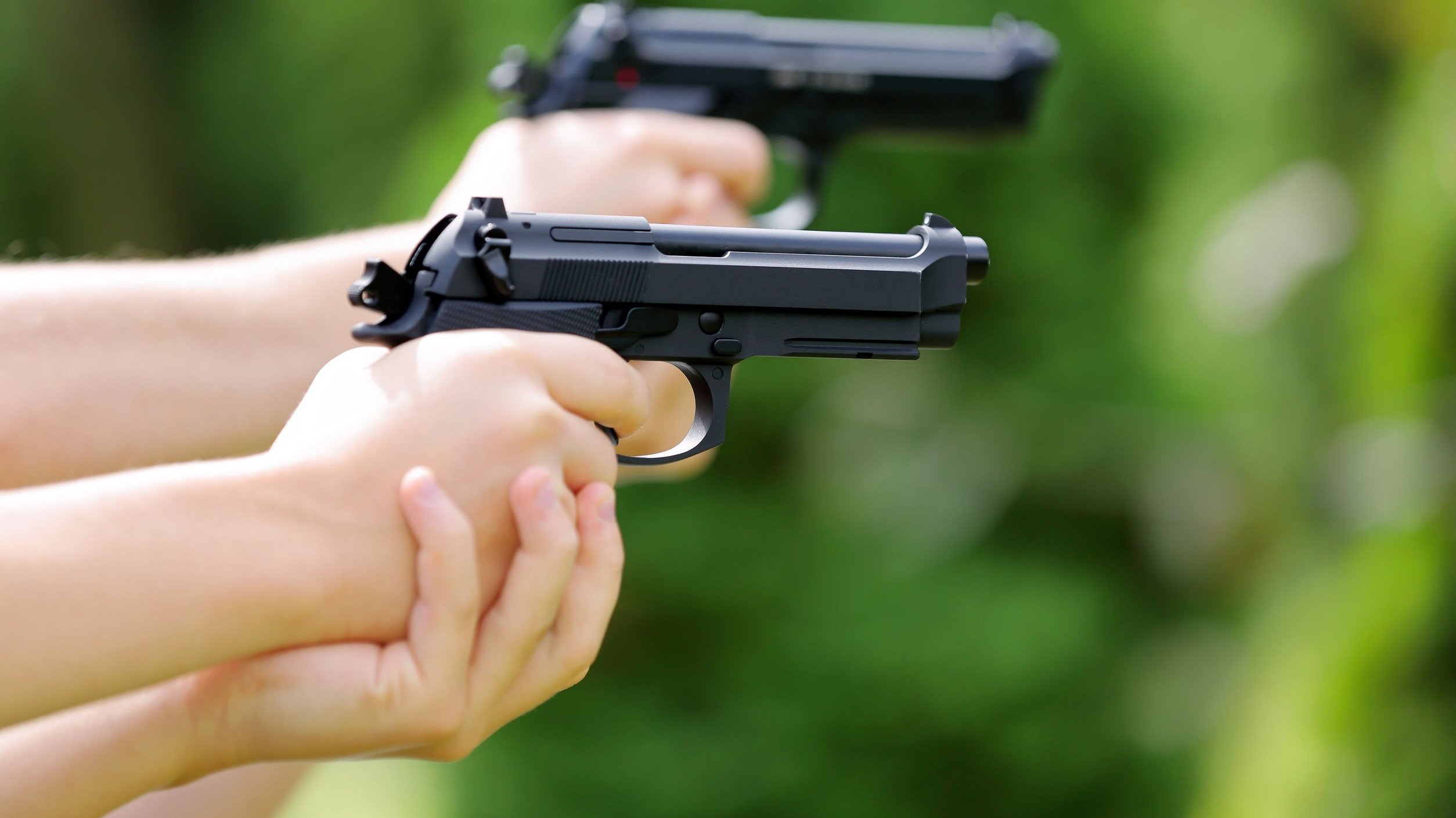 Criança e adulto segurando armas