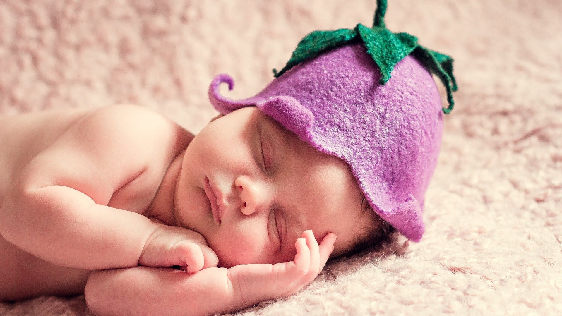 Bebê deitado com chapéu de uva