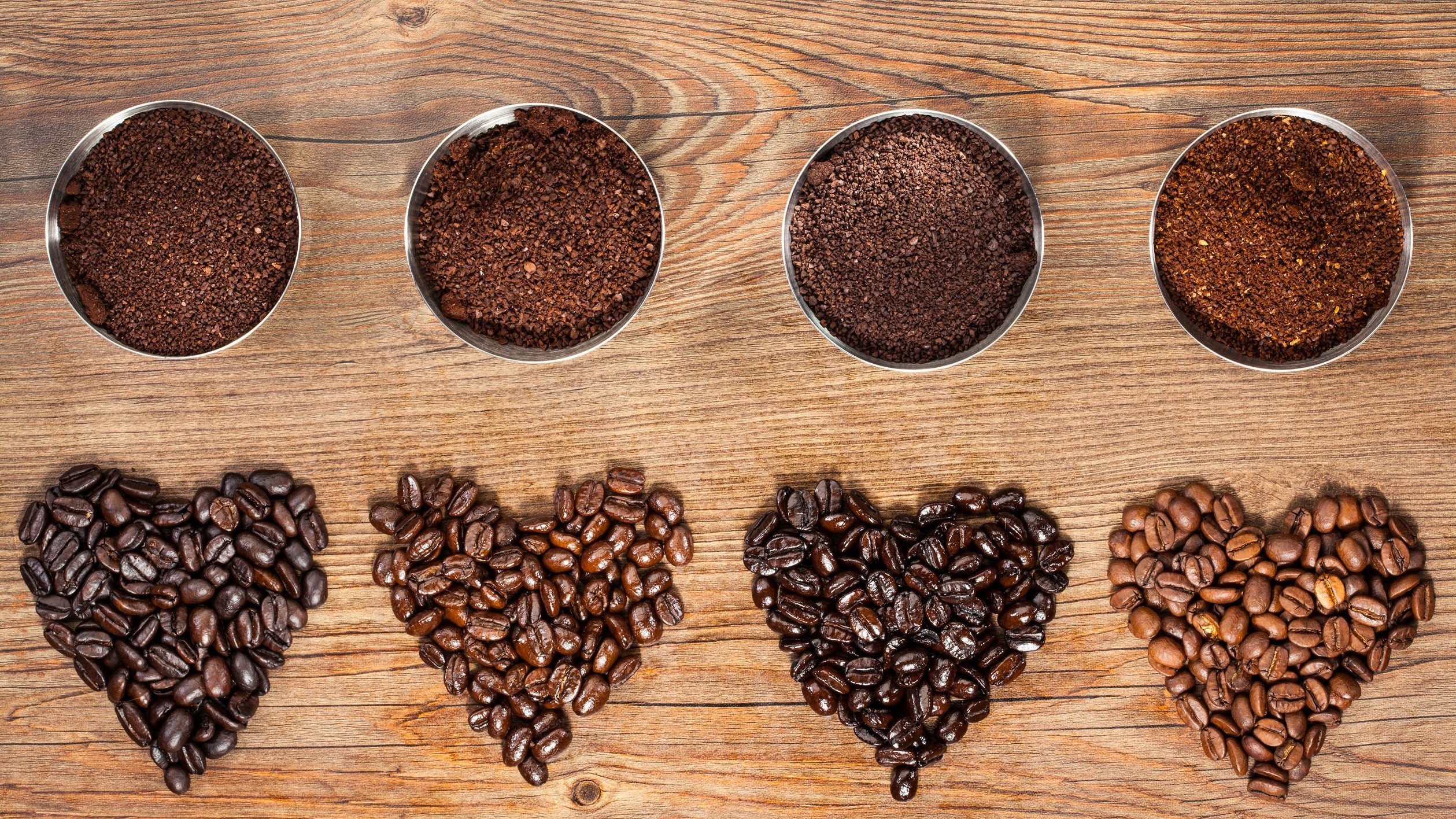 Grãos de café em formato de coração e grãos moídos.