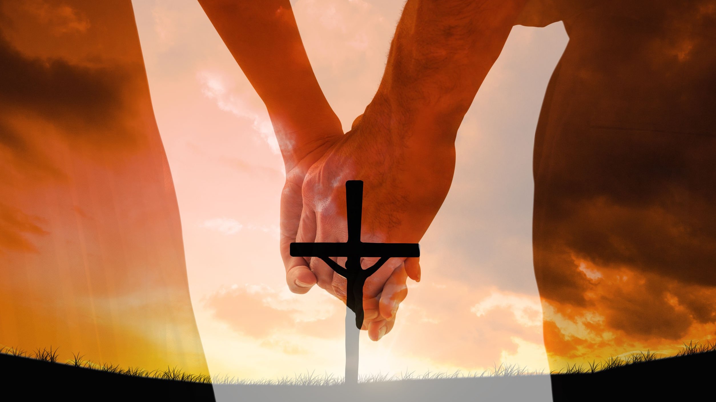 Mãos dadas sob a imagem da cruz.