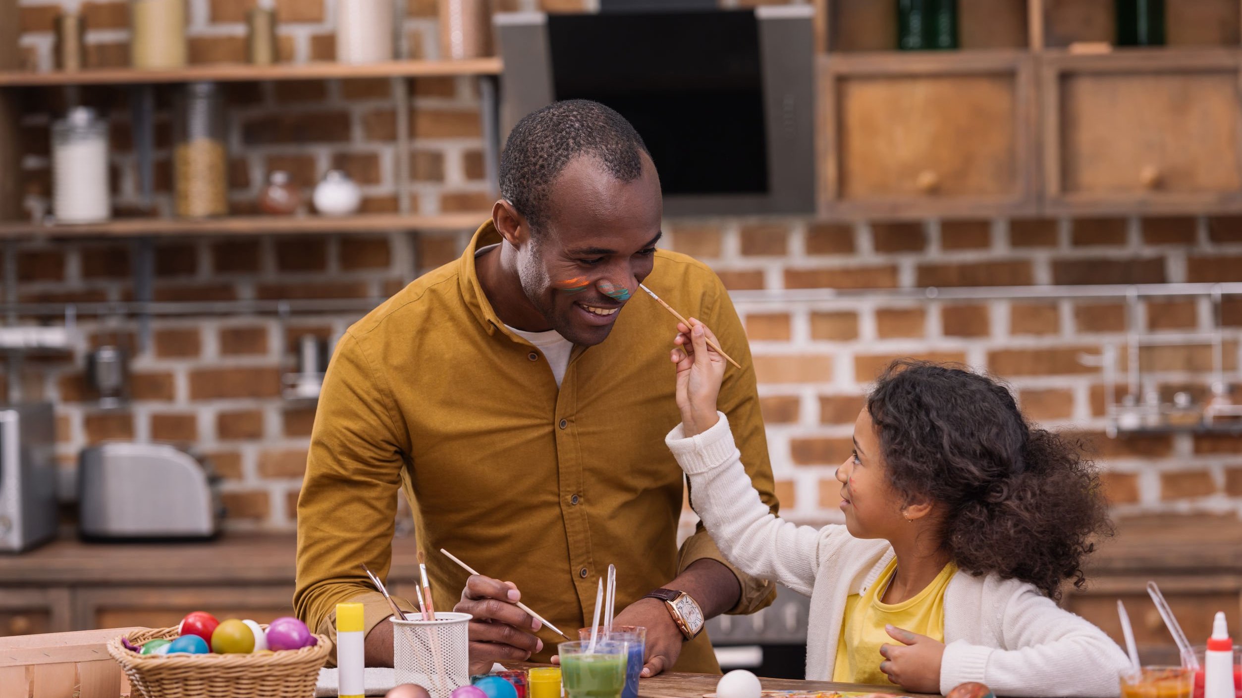 Menina e homem negro pintando.