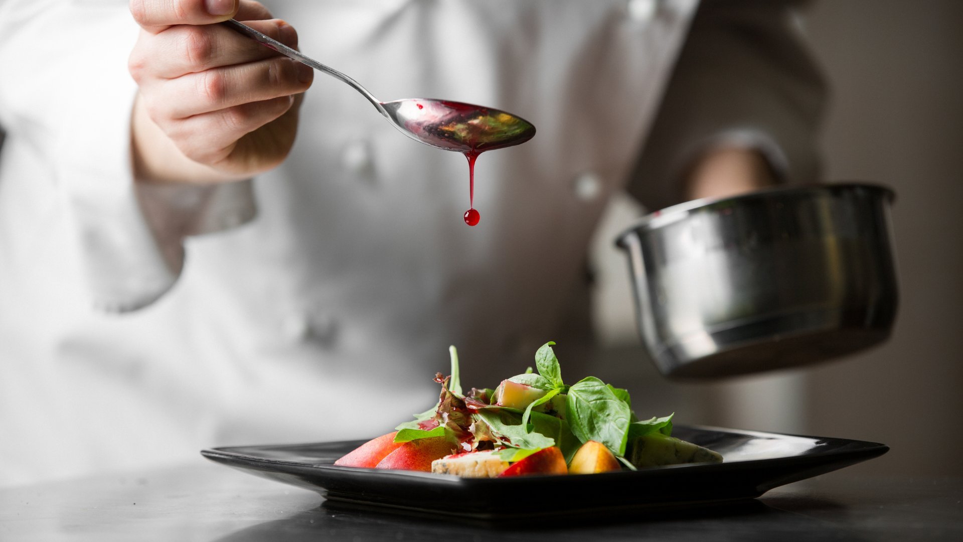 Cozinheira com uma colher terminando um prato