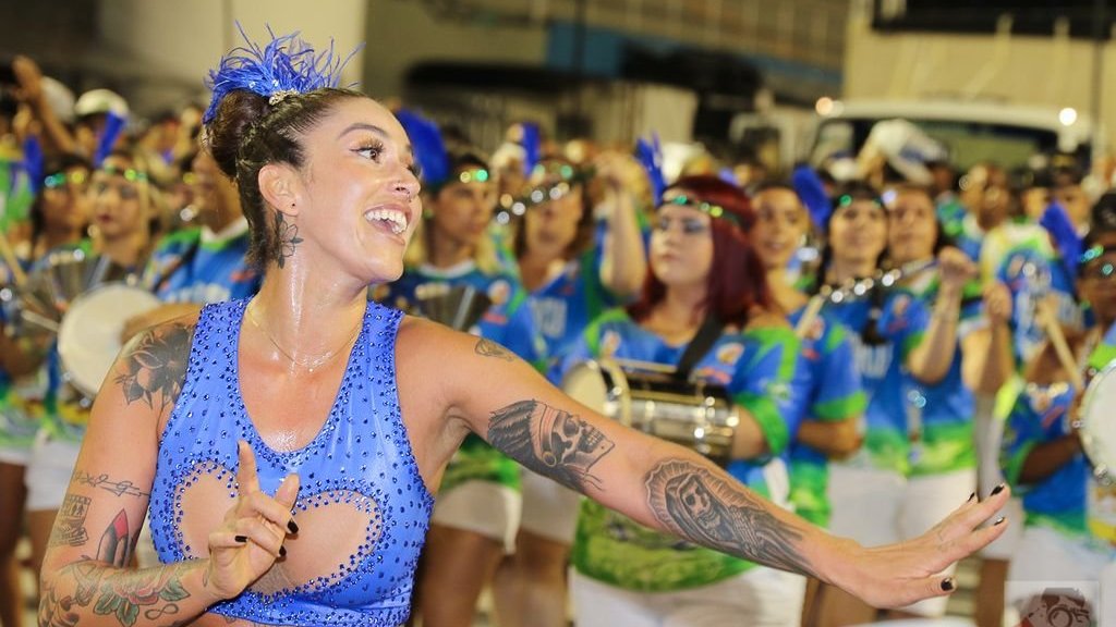 Dani Bolina dançando e sorrindo durante o desfile de carnaval