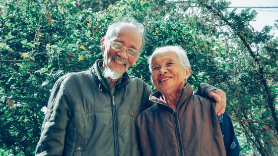 Casal de senhores rindo no jardim