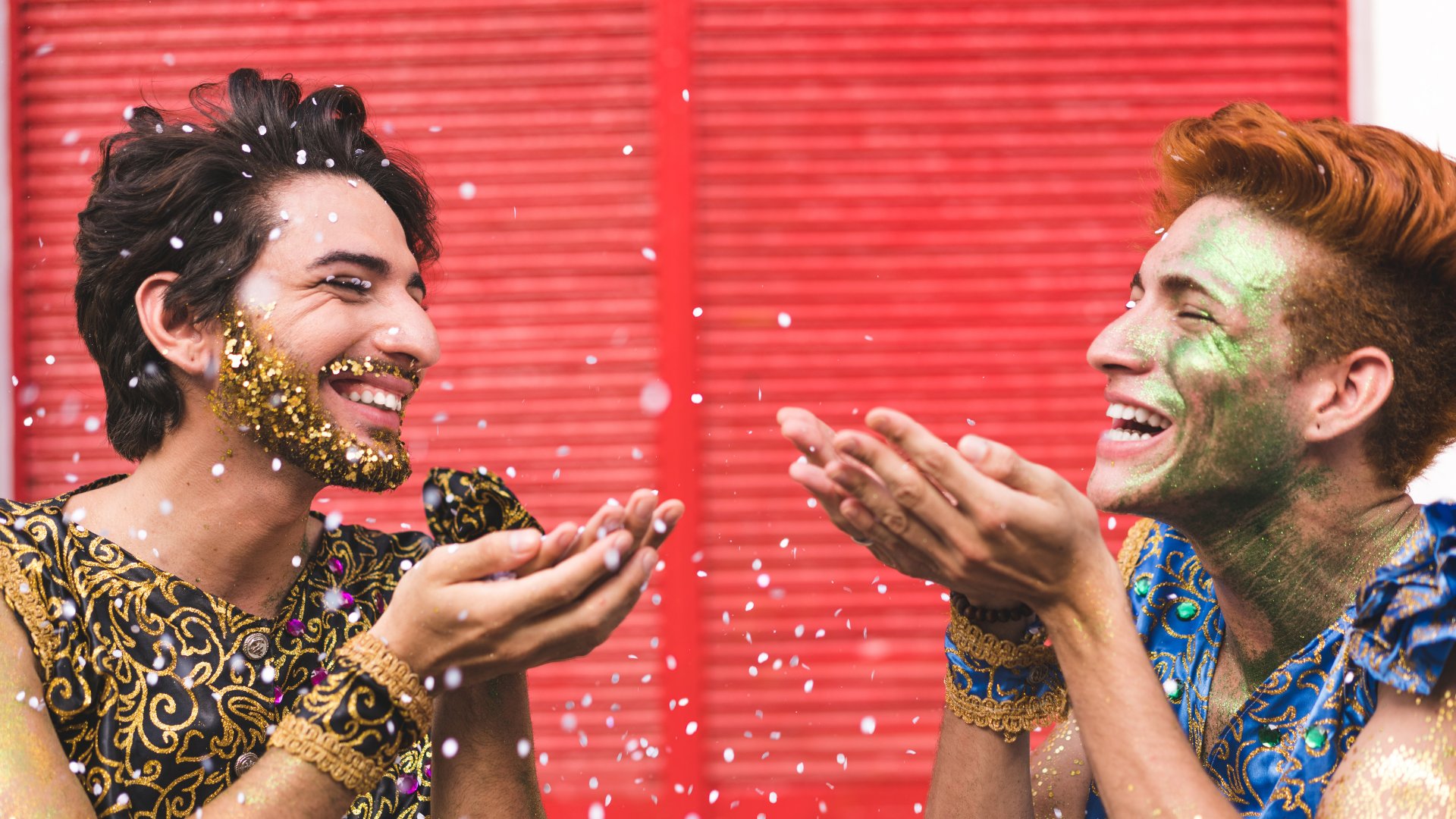 Dois homens sorrindo enquanto jogam confete para o alto