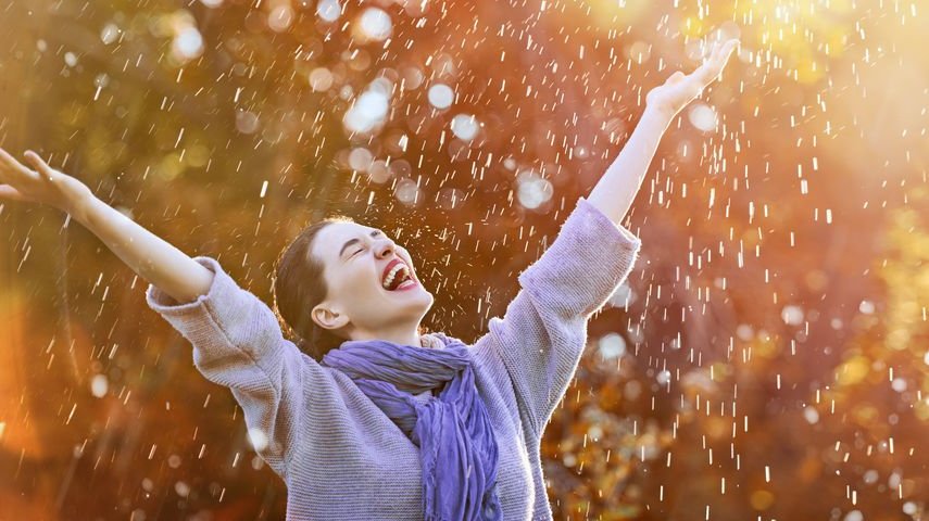 Mulher sorrindo na chuva