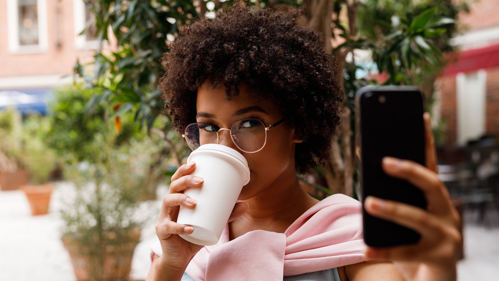 Youngoldman / Getty Images Pro / Canva Mulher tirando selfie sozinha