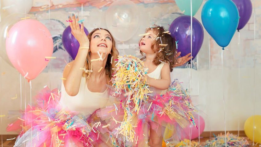 Mulher e menina brancas numa festa de aniversário.