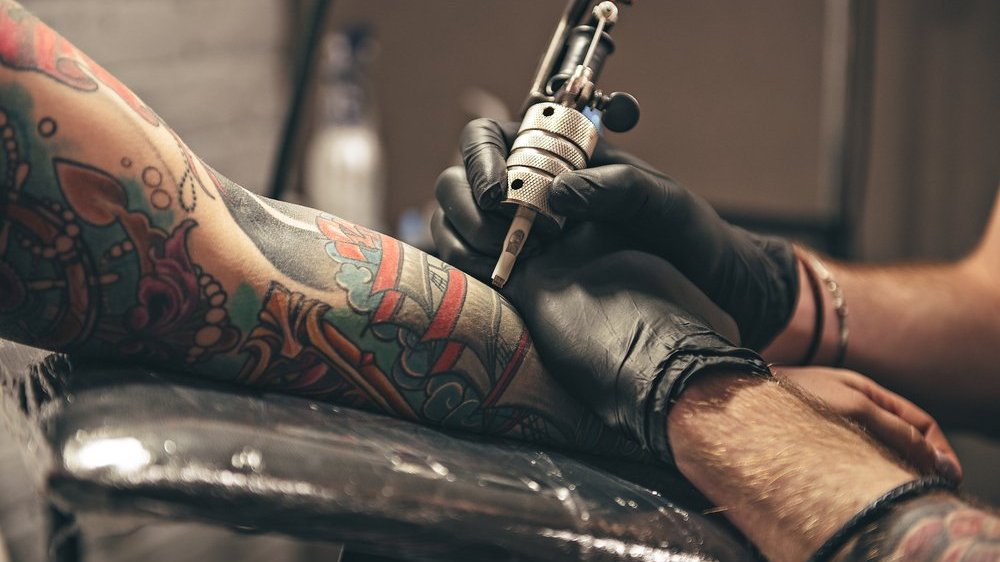 Pessoa sendo tatuada no braço
