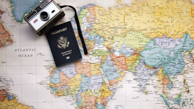 Mapa mundi com um passaporte e uma câmera apoiados na parte de cima
