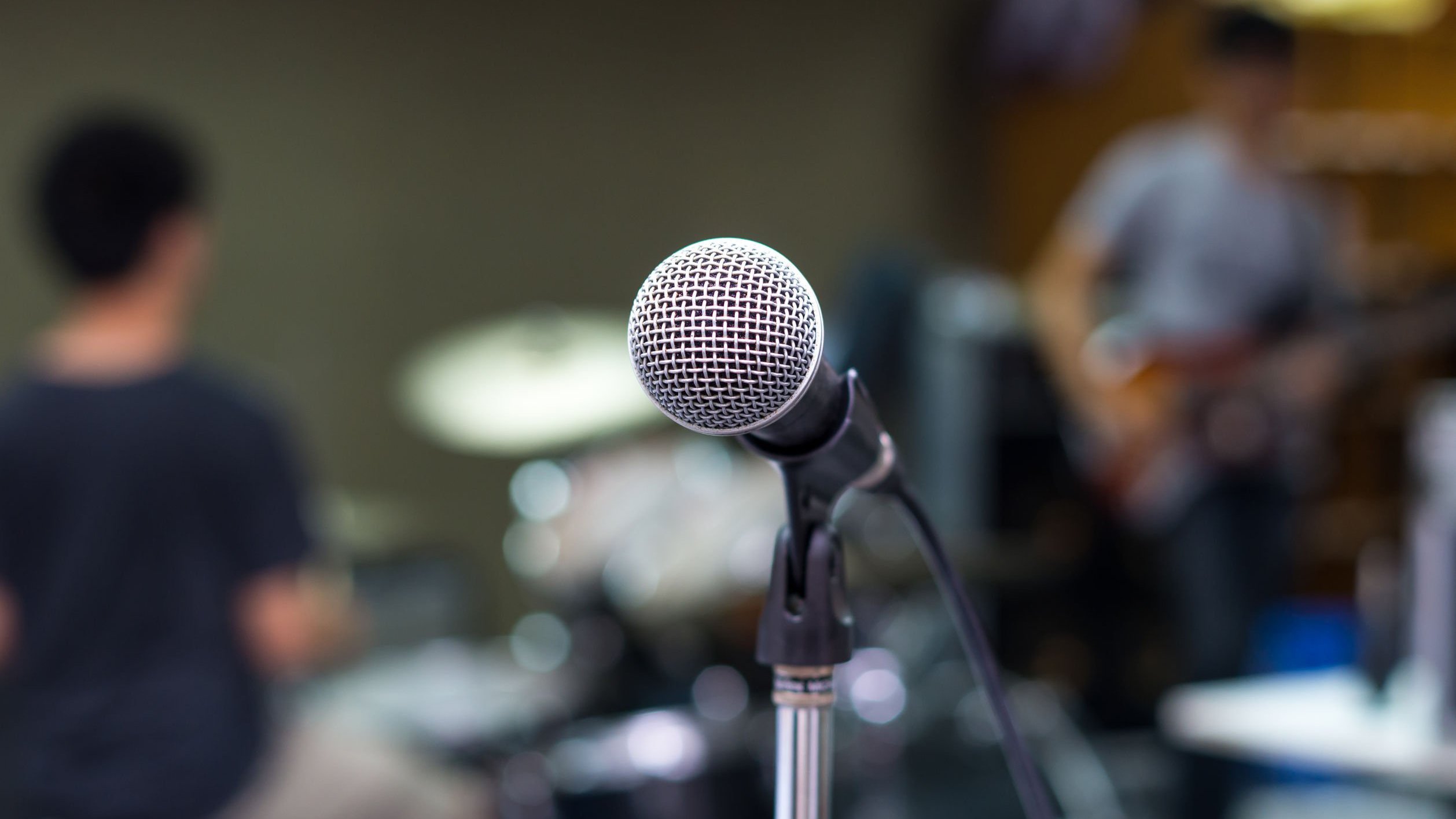 Foto de microfone em estúdio, com fundo desfocado