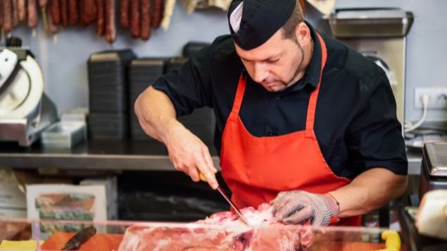 Açougueiro cortando carne