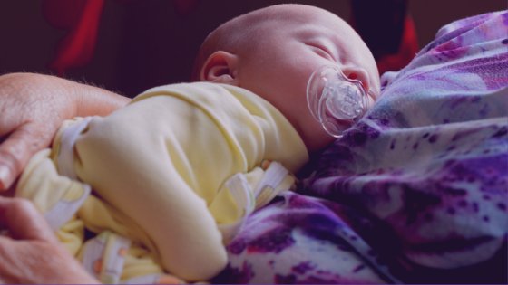 John Finkelstein/Pexels Bebê dormindo no colo de uma mulher
