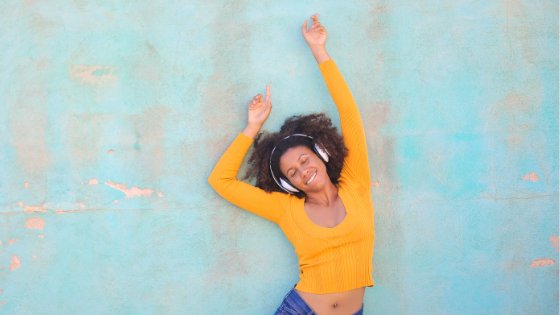 Merias/Canva Mulher escutando música no fone e sorrindo
