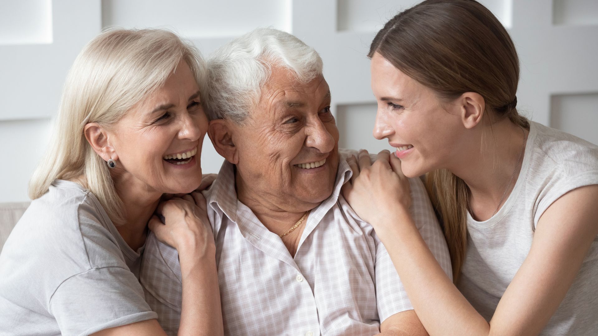 Imagem dos pais com sua filha, os três estão sorrindo e juntos um do outro.