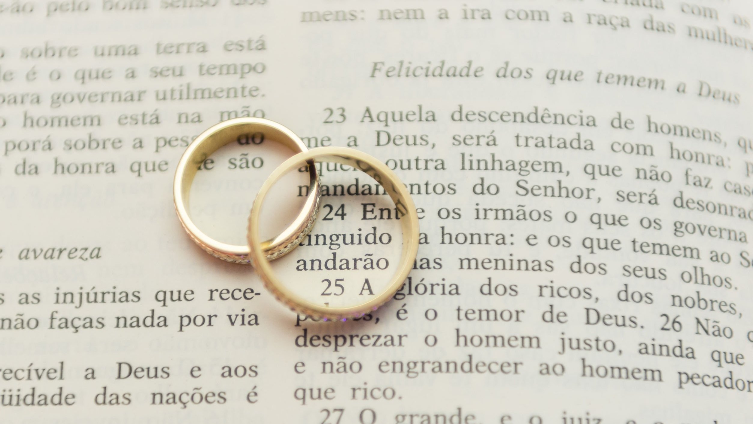 Alianças de casamento sobre bíblia aberta.