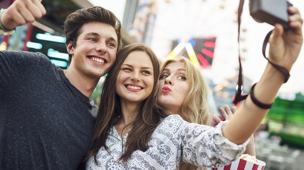 Três amigos tirando uma selfie