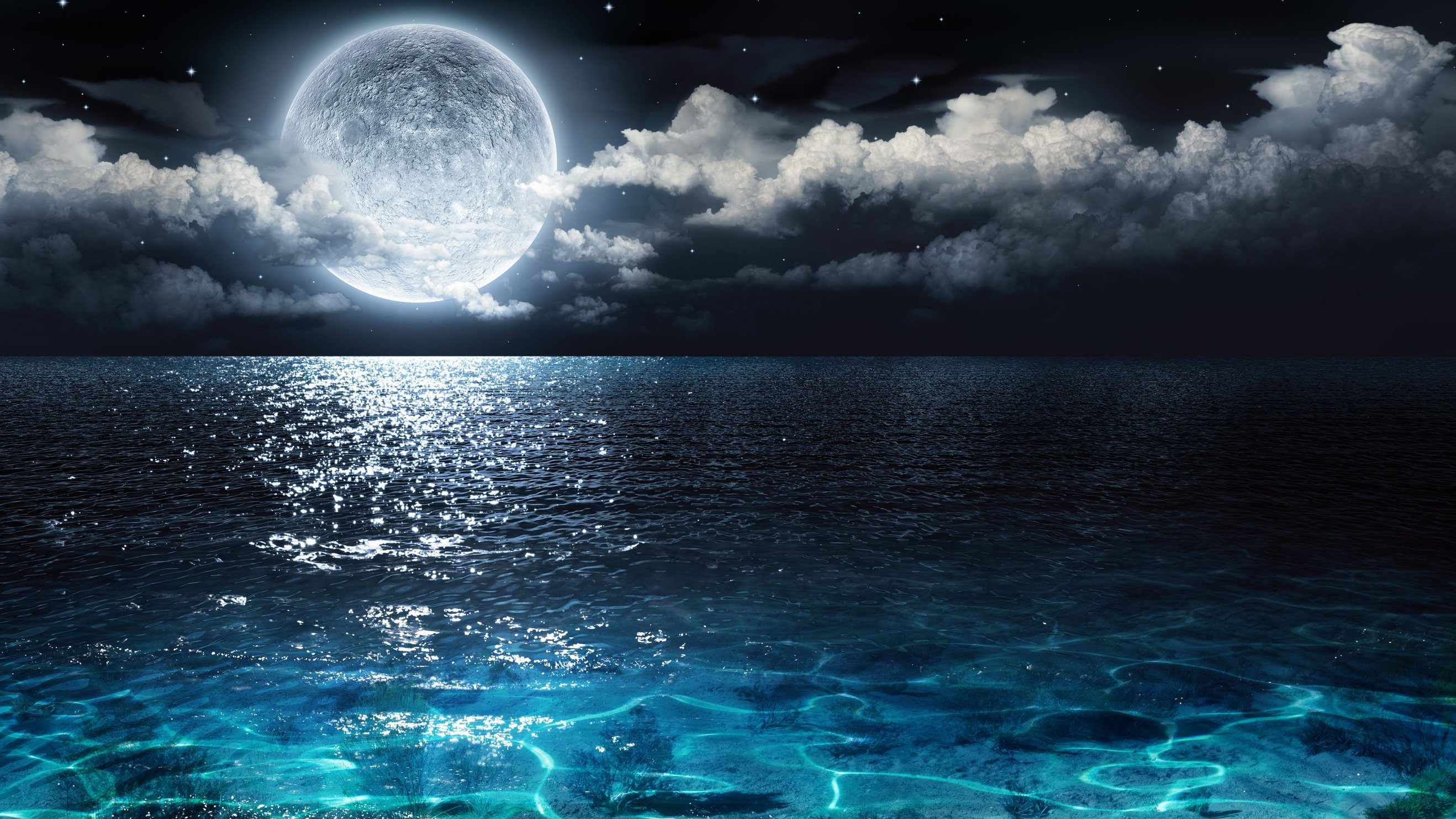 Céu estrelado e reflexo da lua no mar.