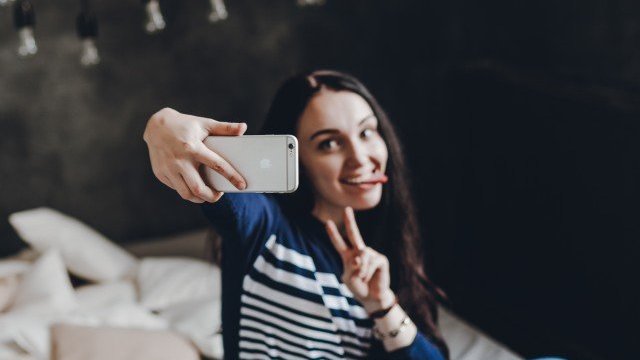 Mulher tirando selfie com a língua para fora