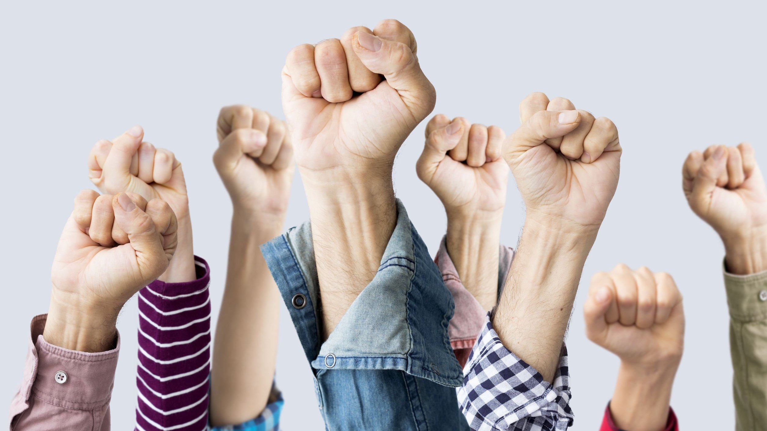 Foto de braços esticados e mãos fechadas representando força