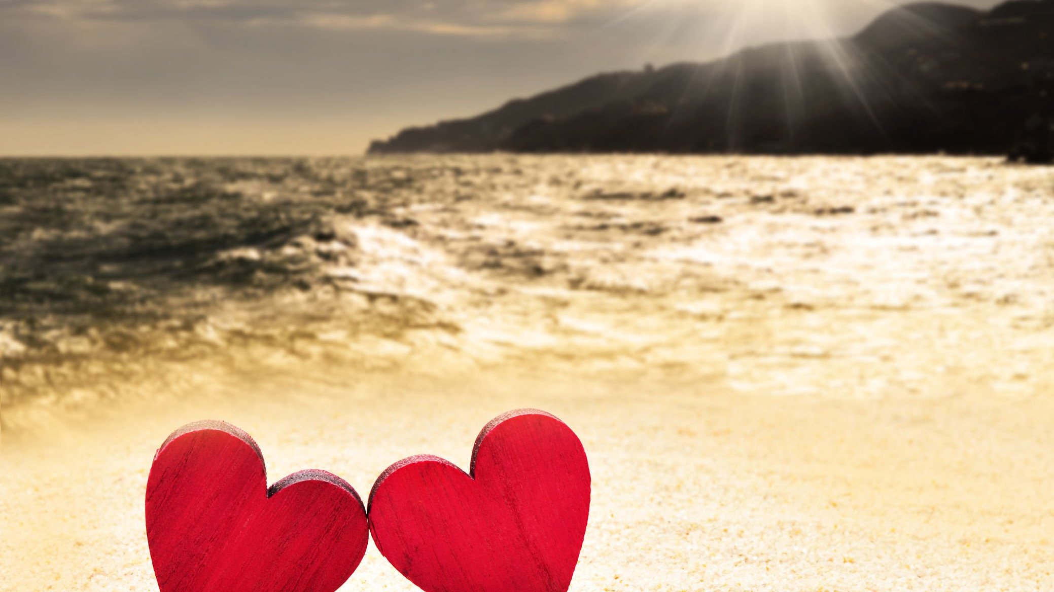 Imagem de dois corações em uma praia
