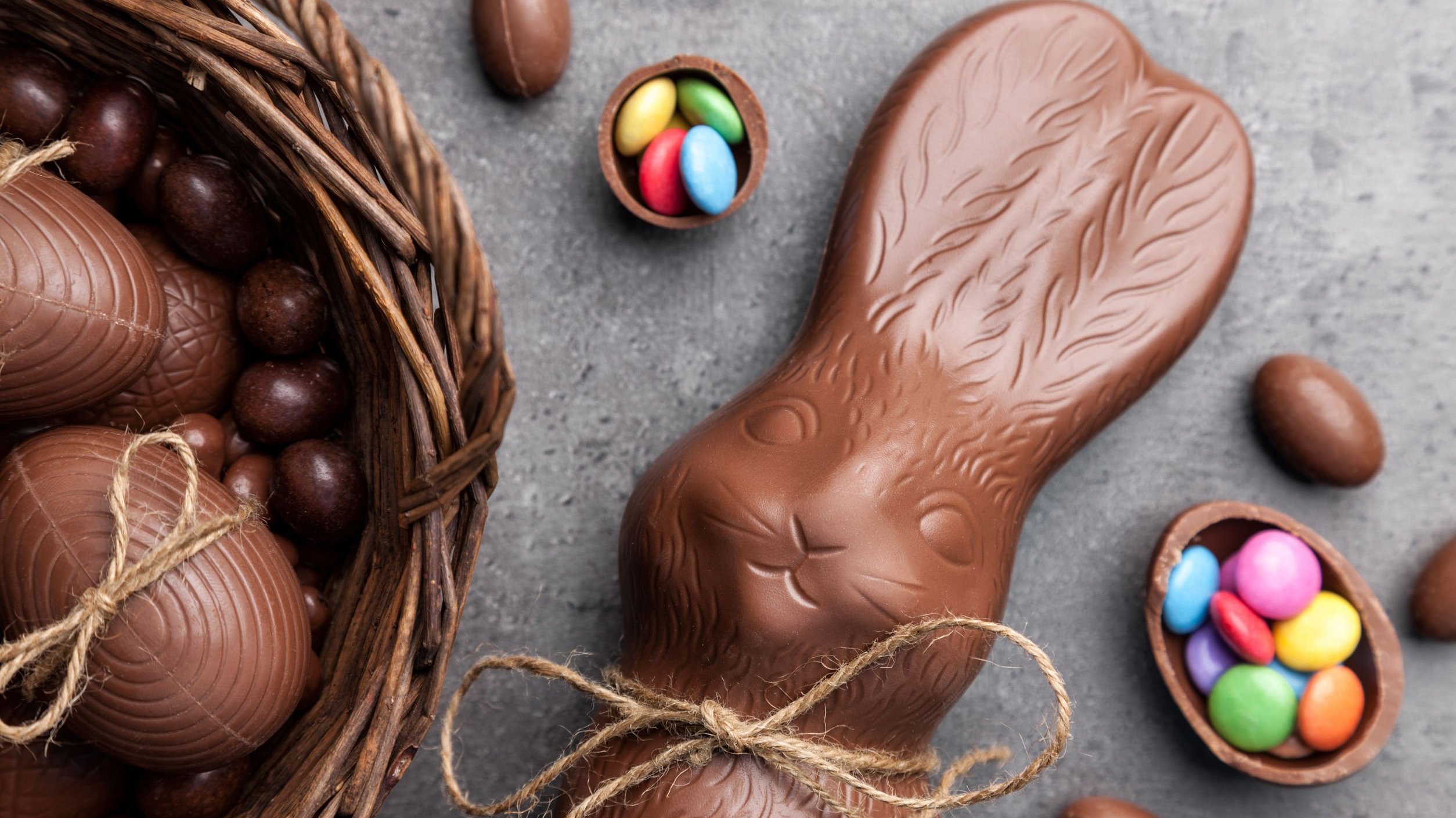 Ovos de chocolate recheados com doces coloridos, e um coelho de chocolate.