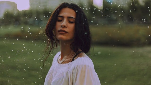 Anastasiya Lobanovskaya / Pexels Mulher branca de olhos fechados tomando chuva.