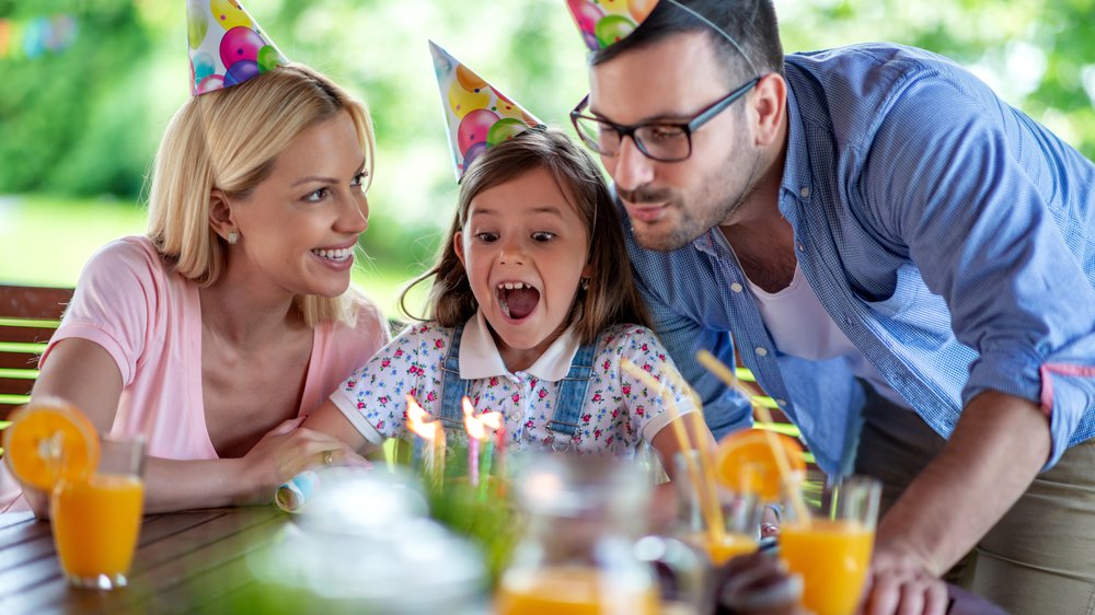 Mãe e pai comemorando aniversário de filha.