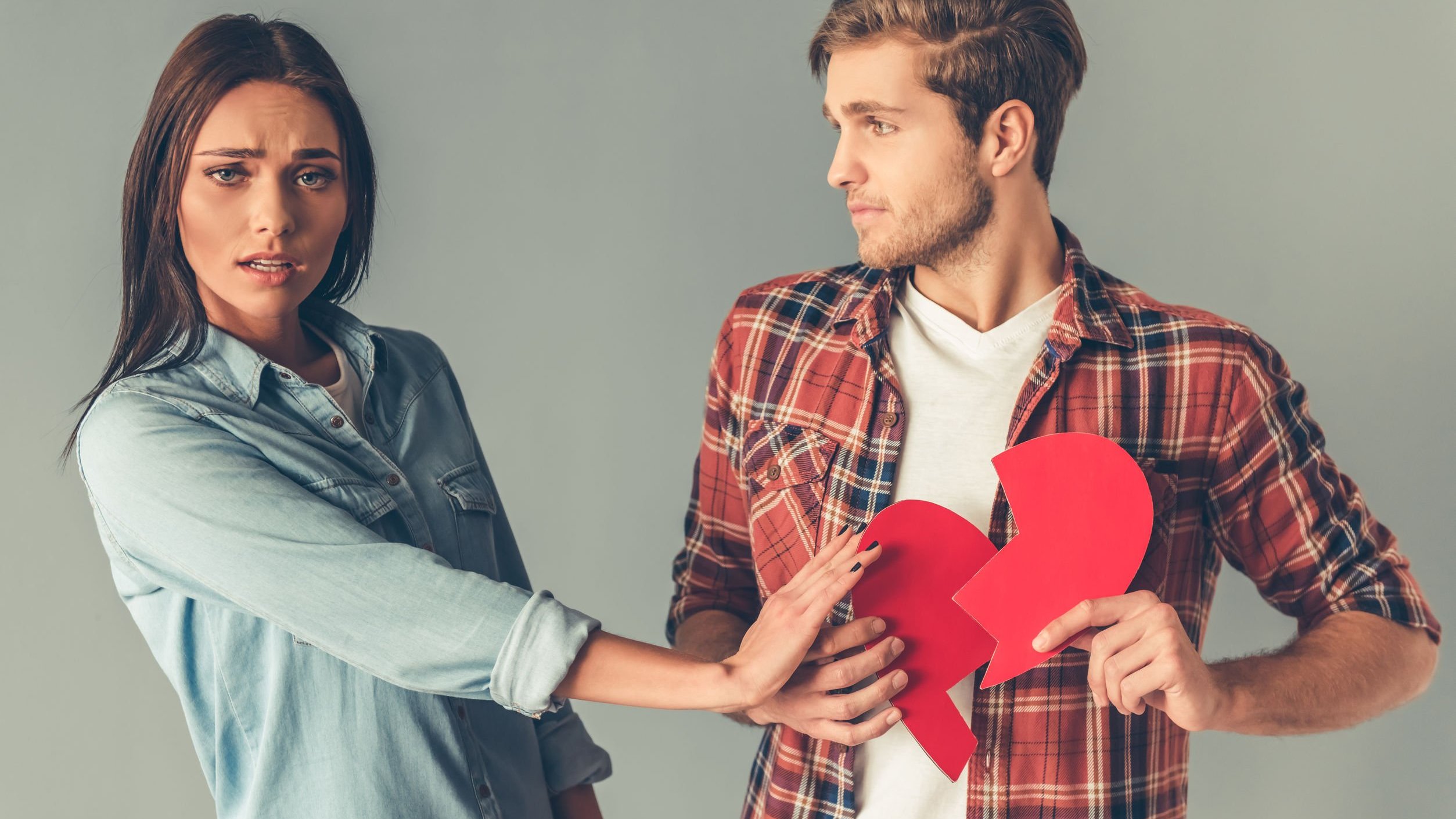 Homem e mulher com coração partido de papel