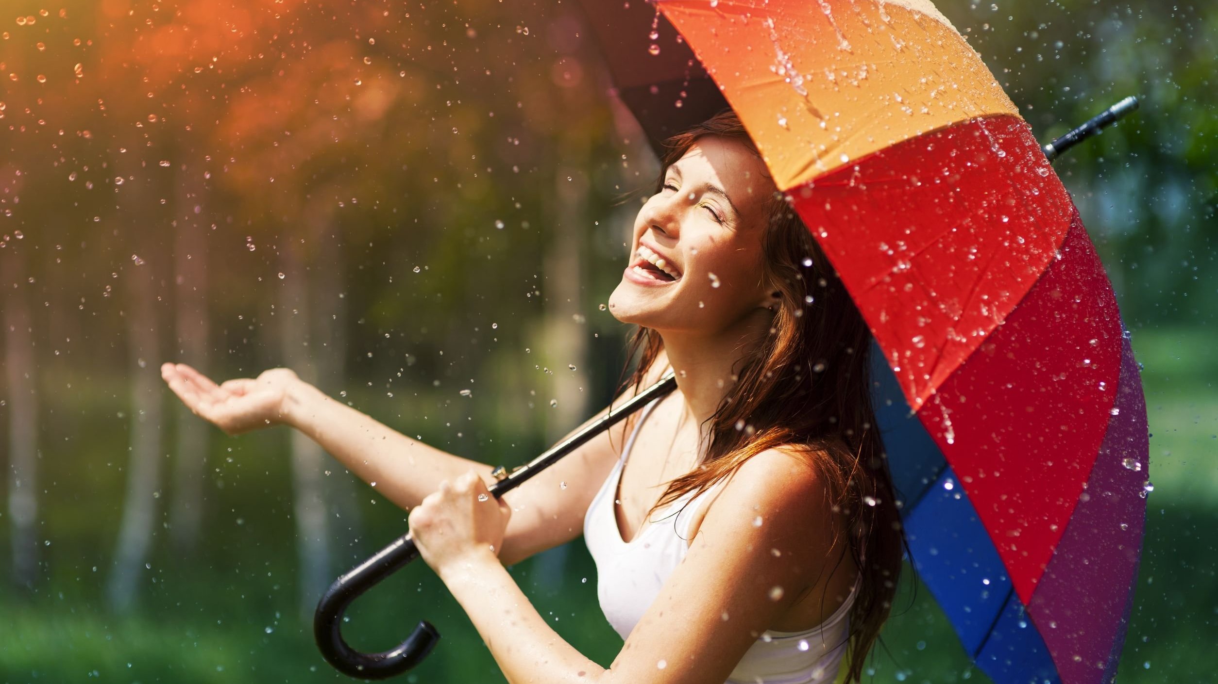 Foto de mulher feliz com guarda chuva na chuva
