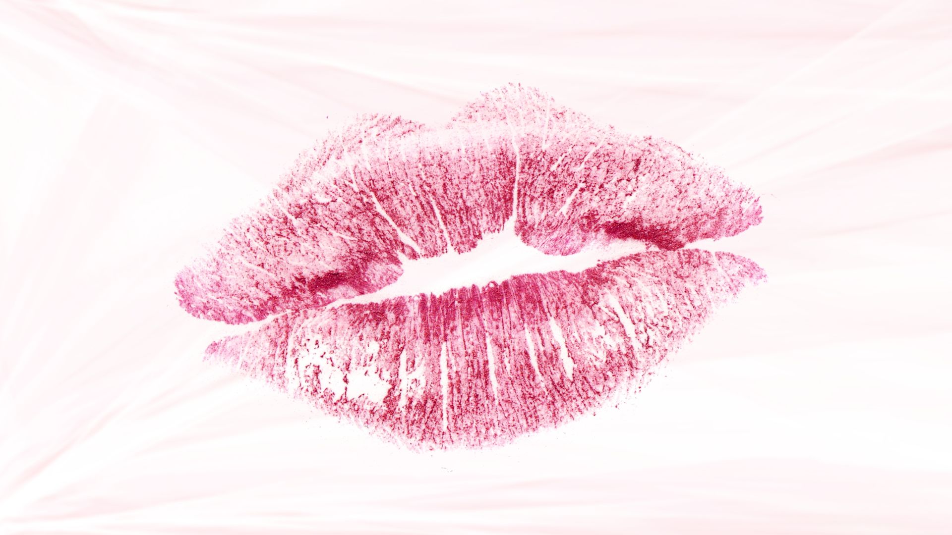 Imagem de uma boca com batom rosa, simbolizando um beijo.