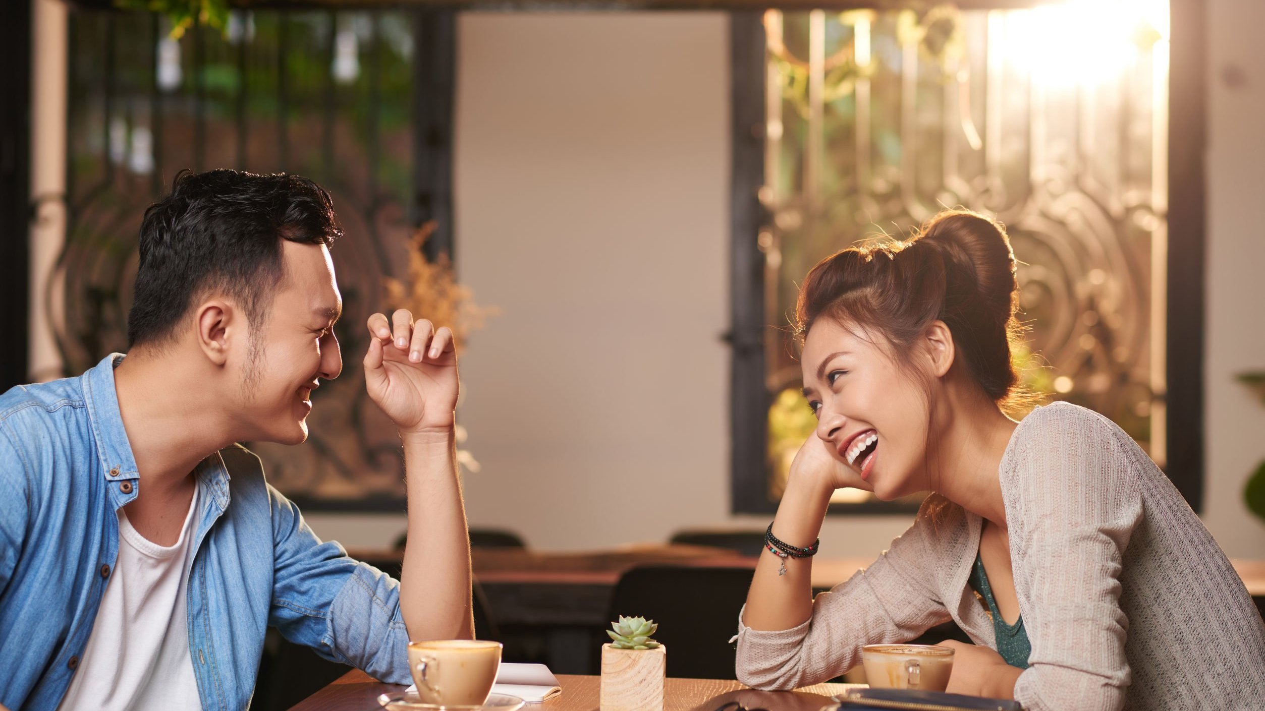 Foto de homem e mulher sentados conversando e sorrindo