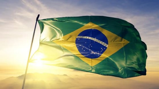 Bandeira do Brasil esvoaçante ao pôr do sol.