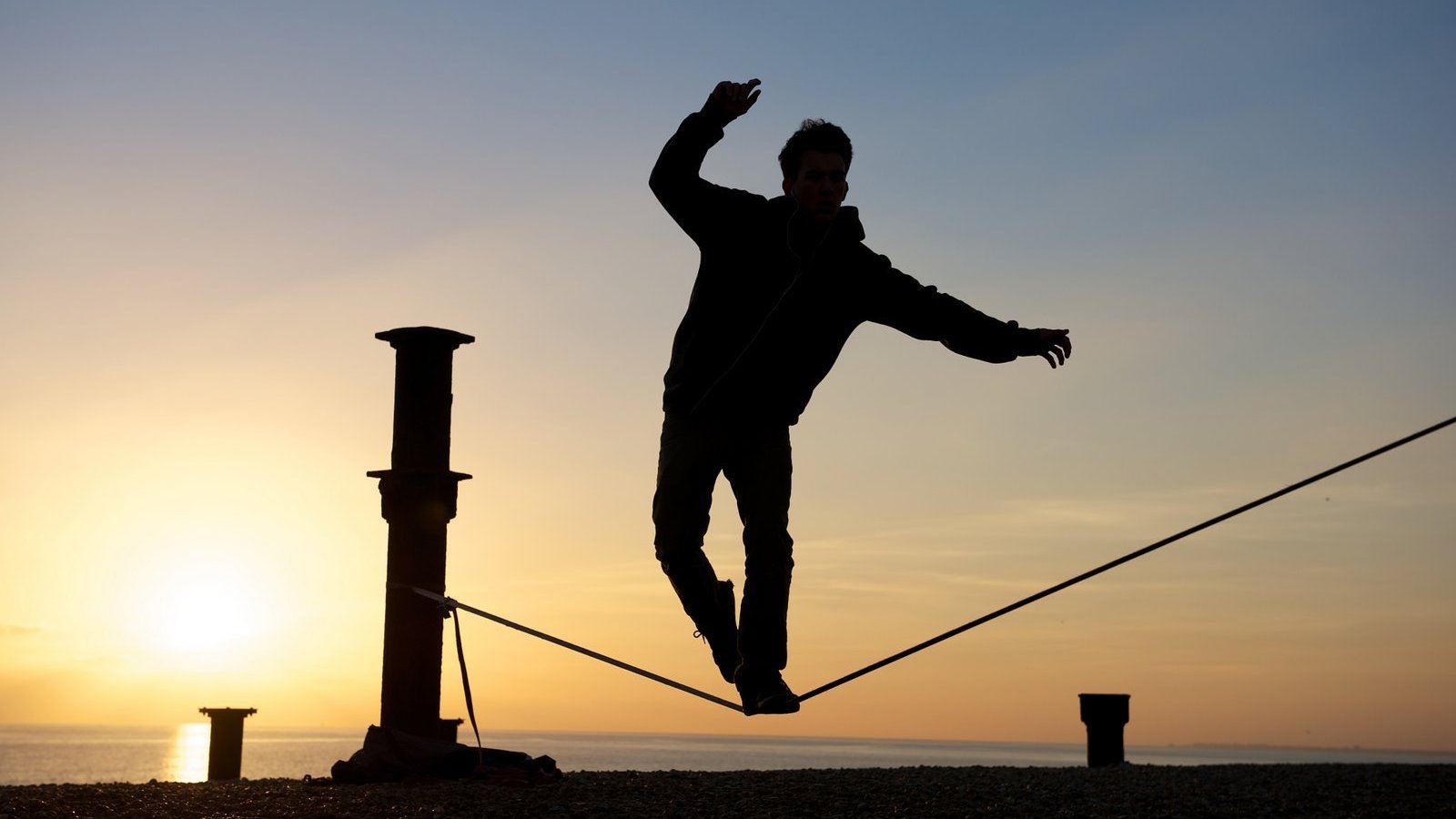 Silhueta de pessoa se equilibrando em corda bamba