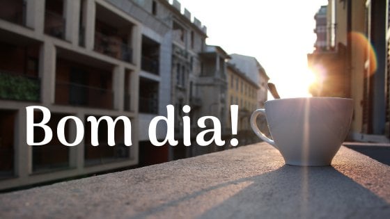 Imagem de xícara de café na janela com sol nascendo e escrito: Bom dia!