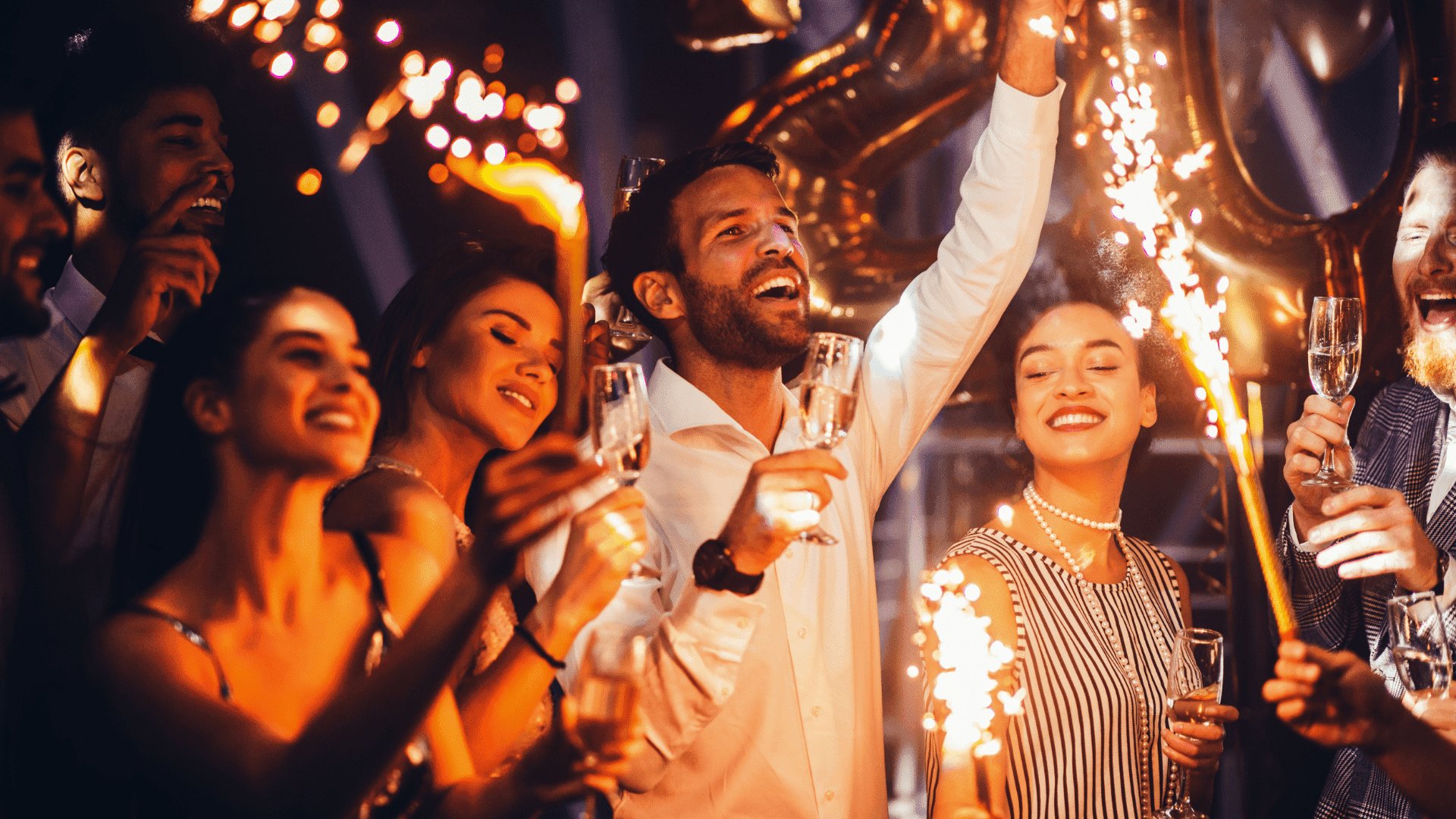 Grupo de amigos comemorando o fim de ano com taças de champanhe