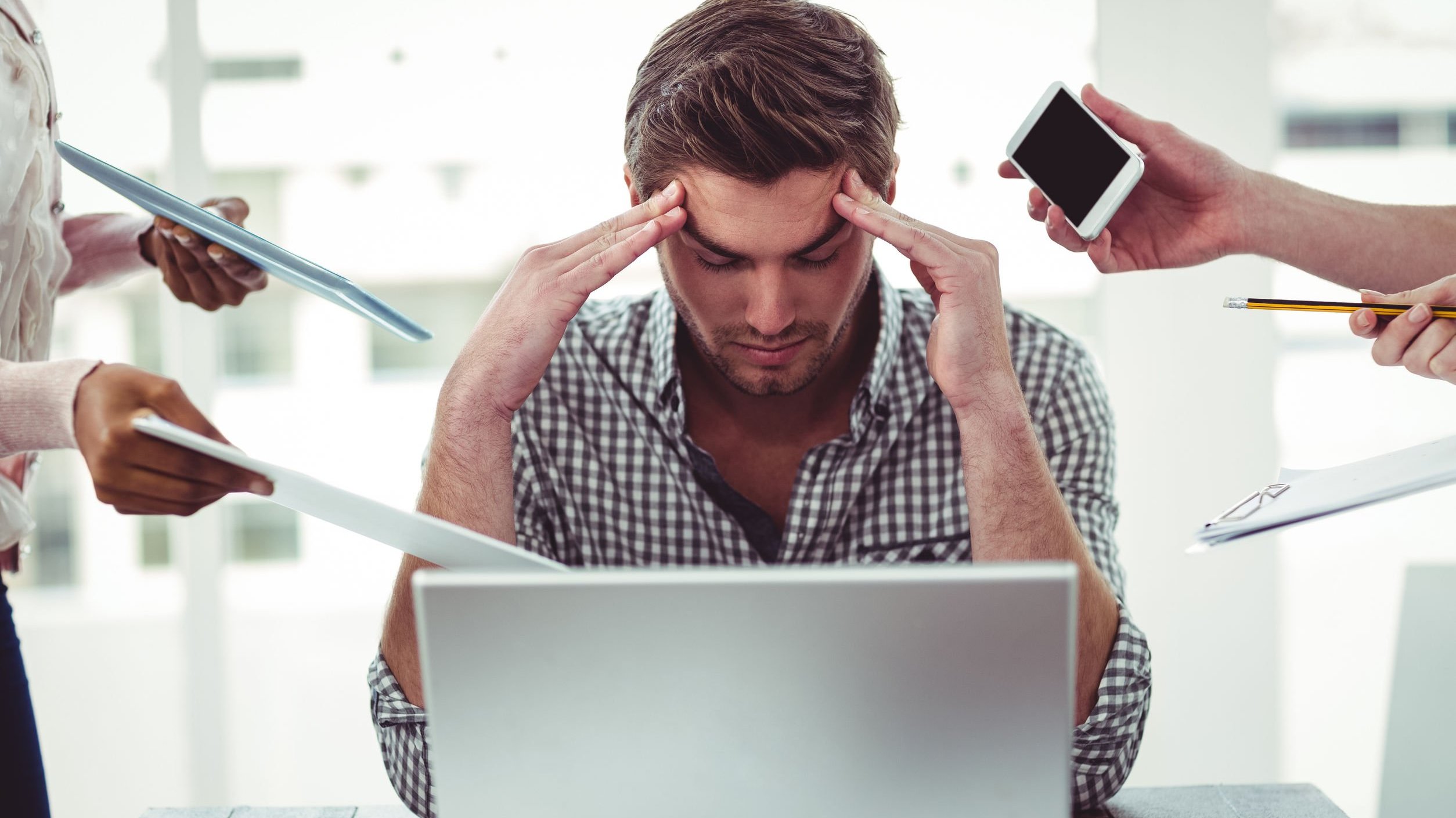 Homem estressado em ambiente de trabalho.