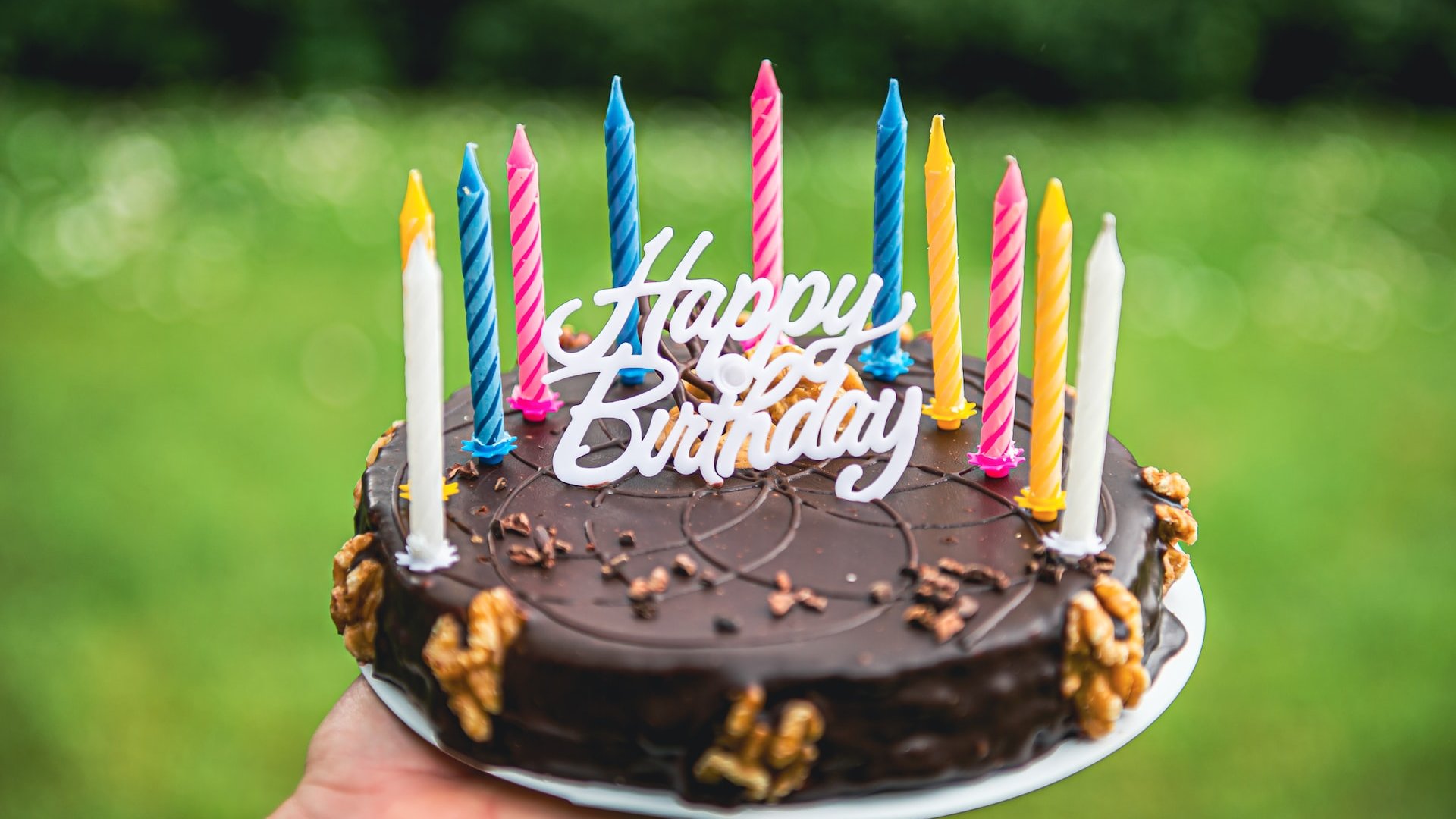 Imants Kaziļuns / Unsplash Bolo com cobertura de chocolate, com várias velas apagadas e um