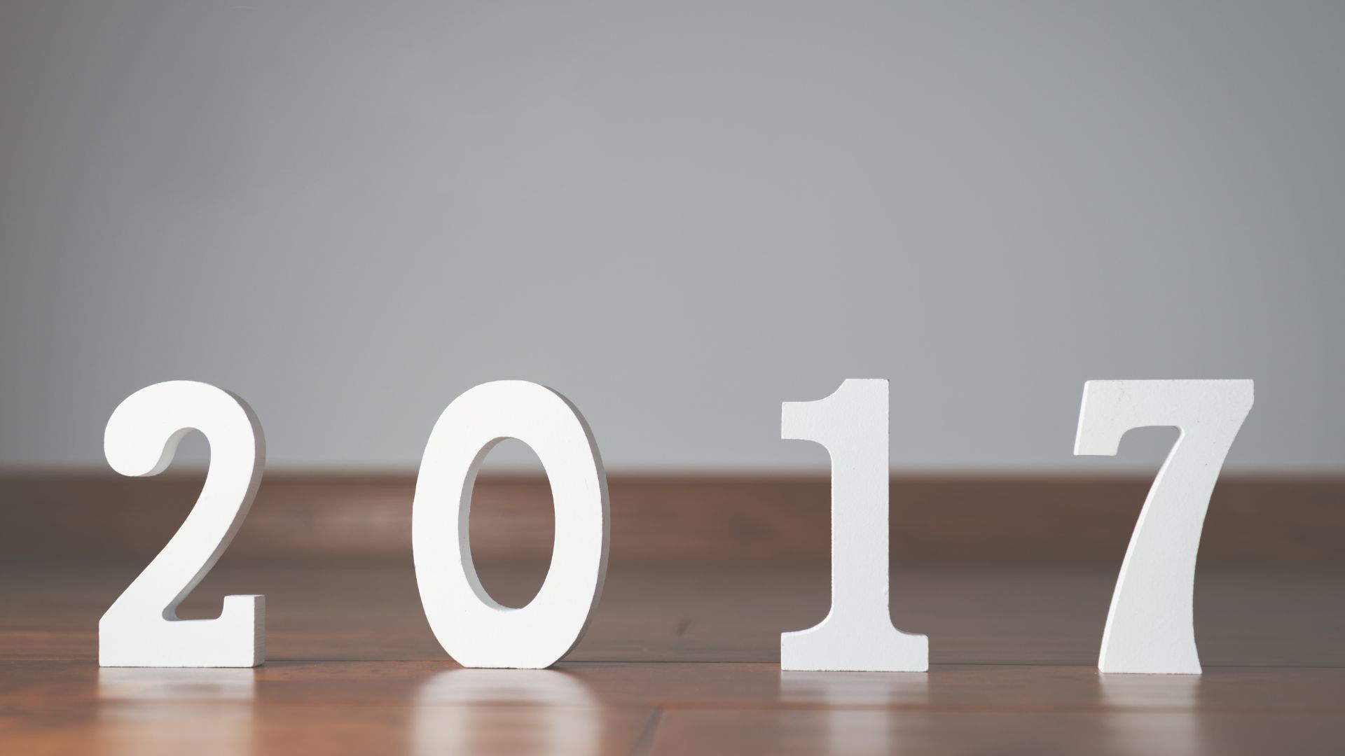 Imagem de fundo cinza, trazendo o número de 2017 escrito em branco para celabrar a entrada deste novo ano.