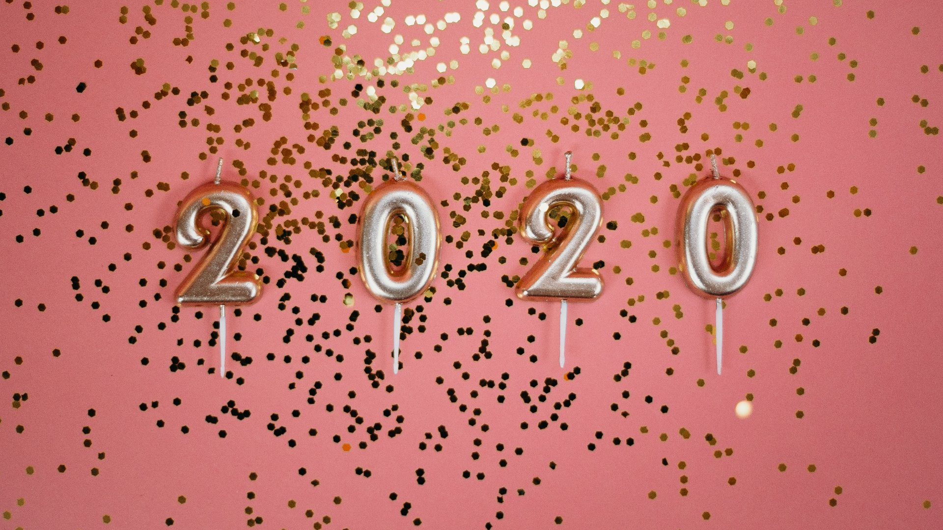 Brilhos e purpurina dourada espalhada com balões que formam 2020