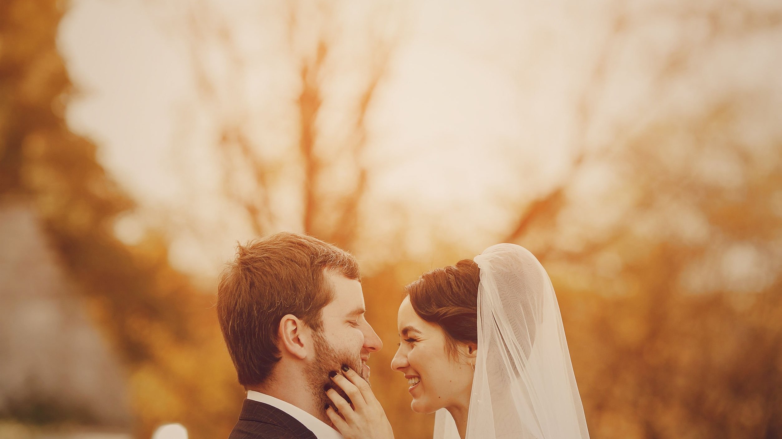 Homem e mulher vestidos para o casamento de frente para o outro sorrindo