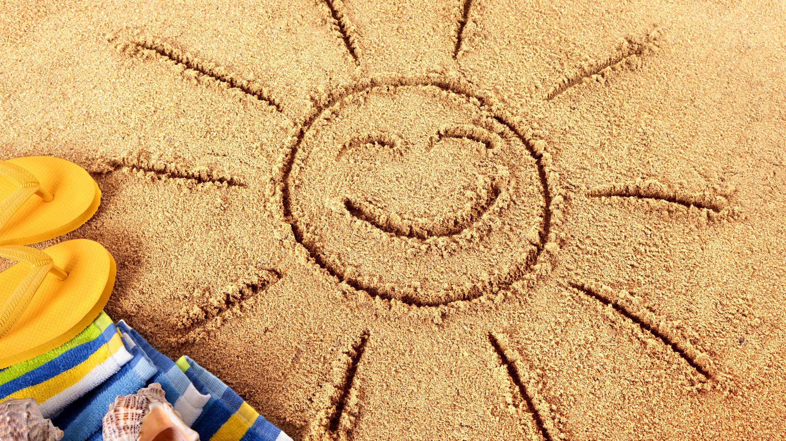 Foto de sol desenhado em areia de praia