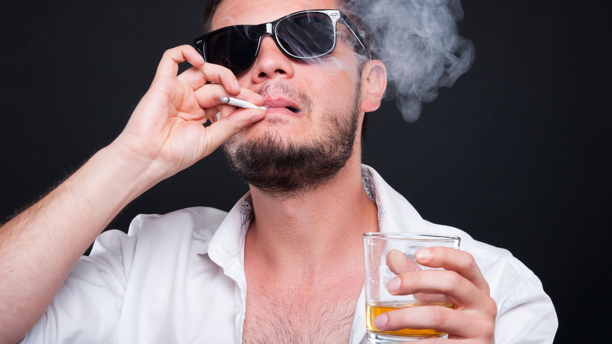 Foto de pessoa malandra fumando charuto e segurando bebida